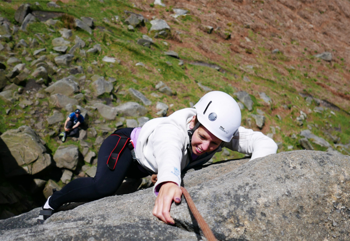 A woman climbing a rock face.