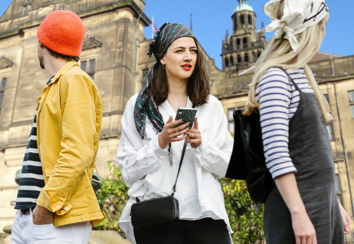Three people having fun on a treasure hunt in Sheffield.