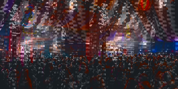 A concert taking place inside a large circus-style tent.