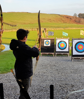 Three people doing archery at the Ringinglow Archery Target Sports Centre.