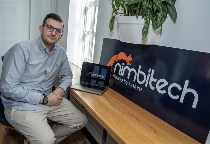 A man sat at a desk with a laptop.