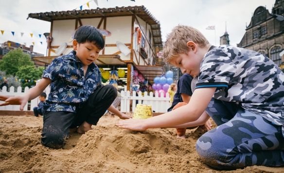 Children are playing in a sandpit that has been set up in the Peace Gardens in Sheffield city centre as part of the Sheffield By The Seaside event.