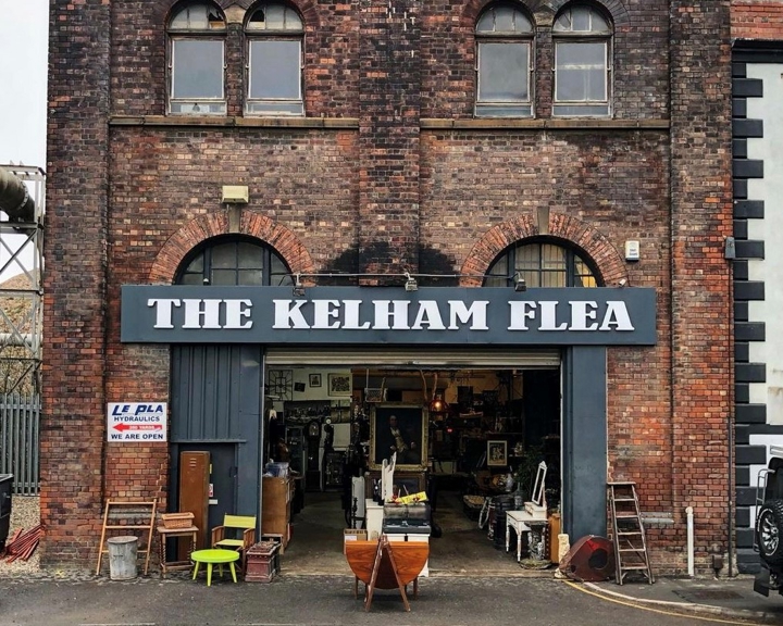Exterior of an old red brick warehouse, over the open doors is a sign that reads 'The Kelham Flea'.