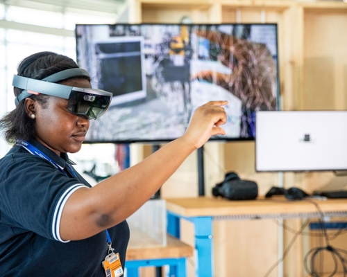 A female nurse uses a headset and enhanced-reality technology. 