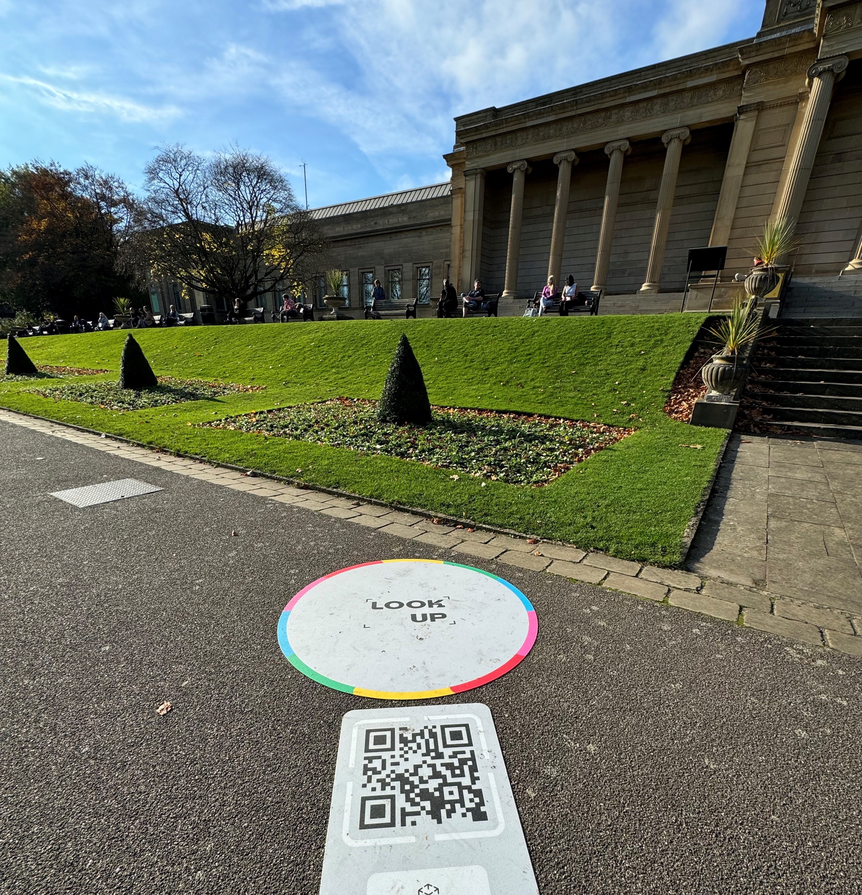 A path outside Weston Park Museum. On the ground is a QR Code that activates the Look Up! AR experience.