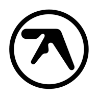 A bold black logo featuring an abstract, angular shape enclosed within a thick circular border. The design is minimalist and geometric, with sharp lines and a distinctive asymmetrical form. The background is plain white, emphasizing the high-contrast black symbol. This is the iconic logo associated with Aphex Twin.