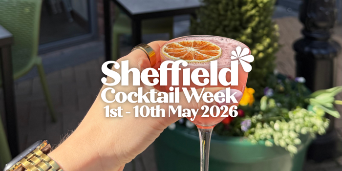 A hand holding a pink cocktail garnished with a dried orange slice in an elegant glass. The background shows outdoor seating and a large green planter with flowers. Overlaid white text reads: “Sheffield Cocktail Week, 1st – 10th May 2026” with a small flower graphic.