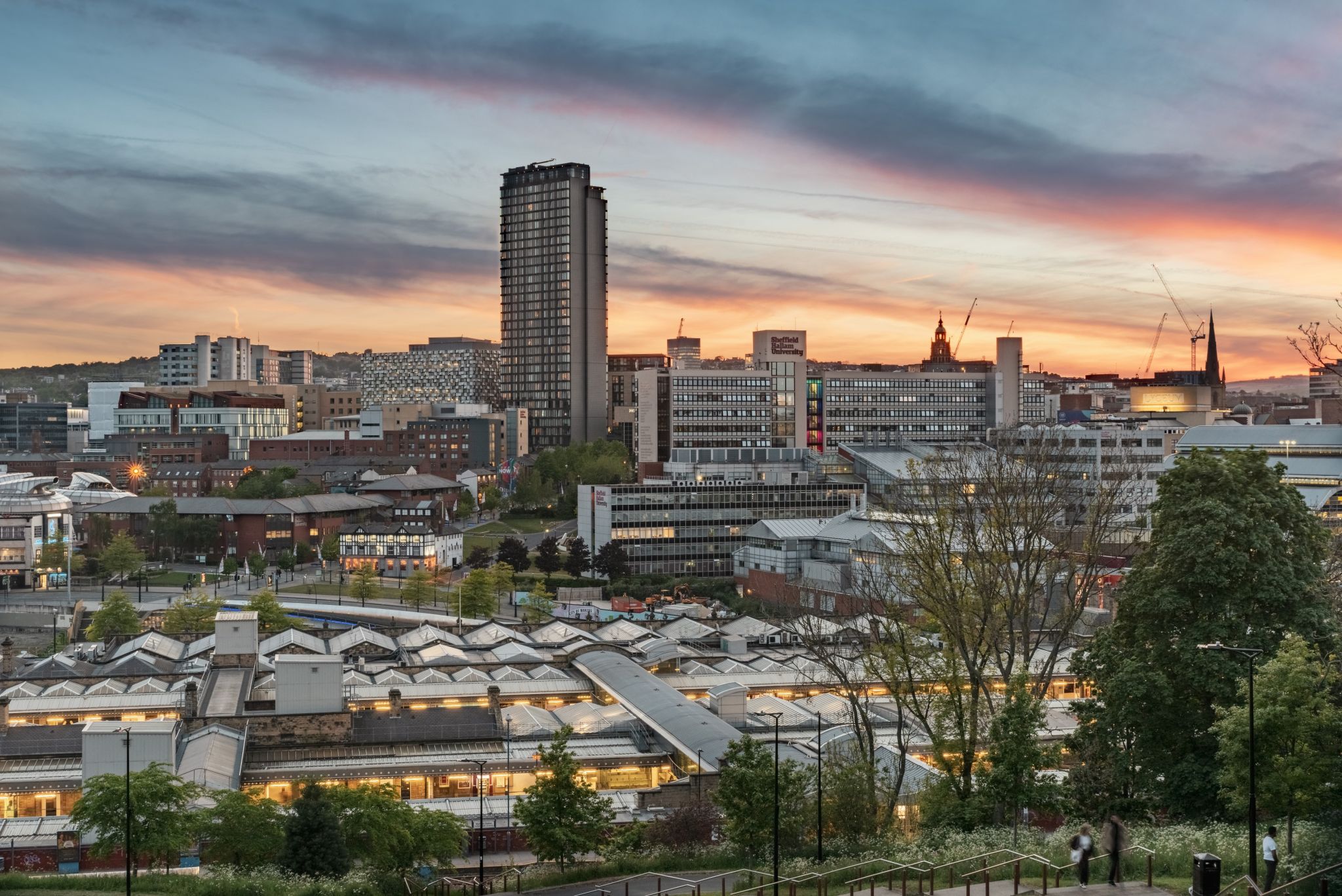 Sheffield city centre and the railway station glow in the twilight, as seen from a neighbouring hill. 