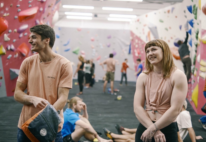 People having fun at an indoors climbing wall.